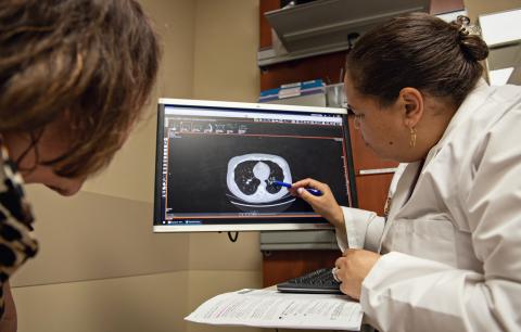 A doctor using computer to explain a condition to patient.